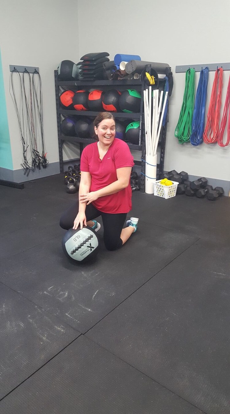Me doing a cheesy pose with a medicine ball after EMOM burpees